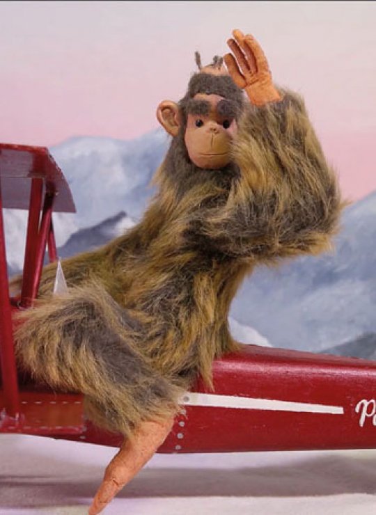 Animation of a monkey sitting on a red plane and waving